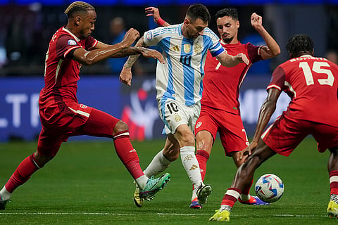 Lionel Messi and Stephen Eustaquio battle for the ball